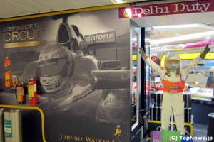 ジョニーウォーカーの広告横にマクラーレン風レーシングスーツ＝F1インドGP