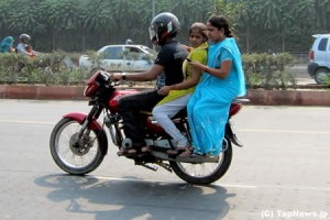 インドの女性はバイクも横乗り、片手でメールチェック